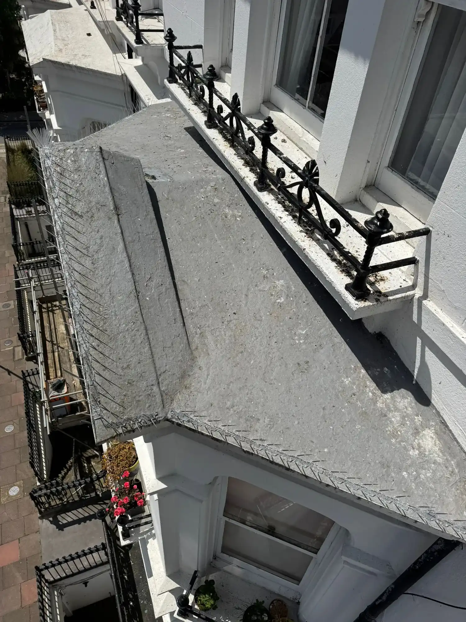 A white building with a black iron railing.