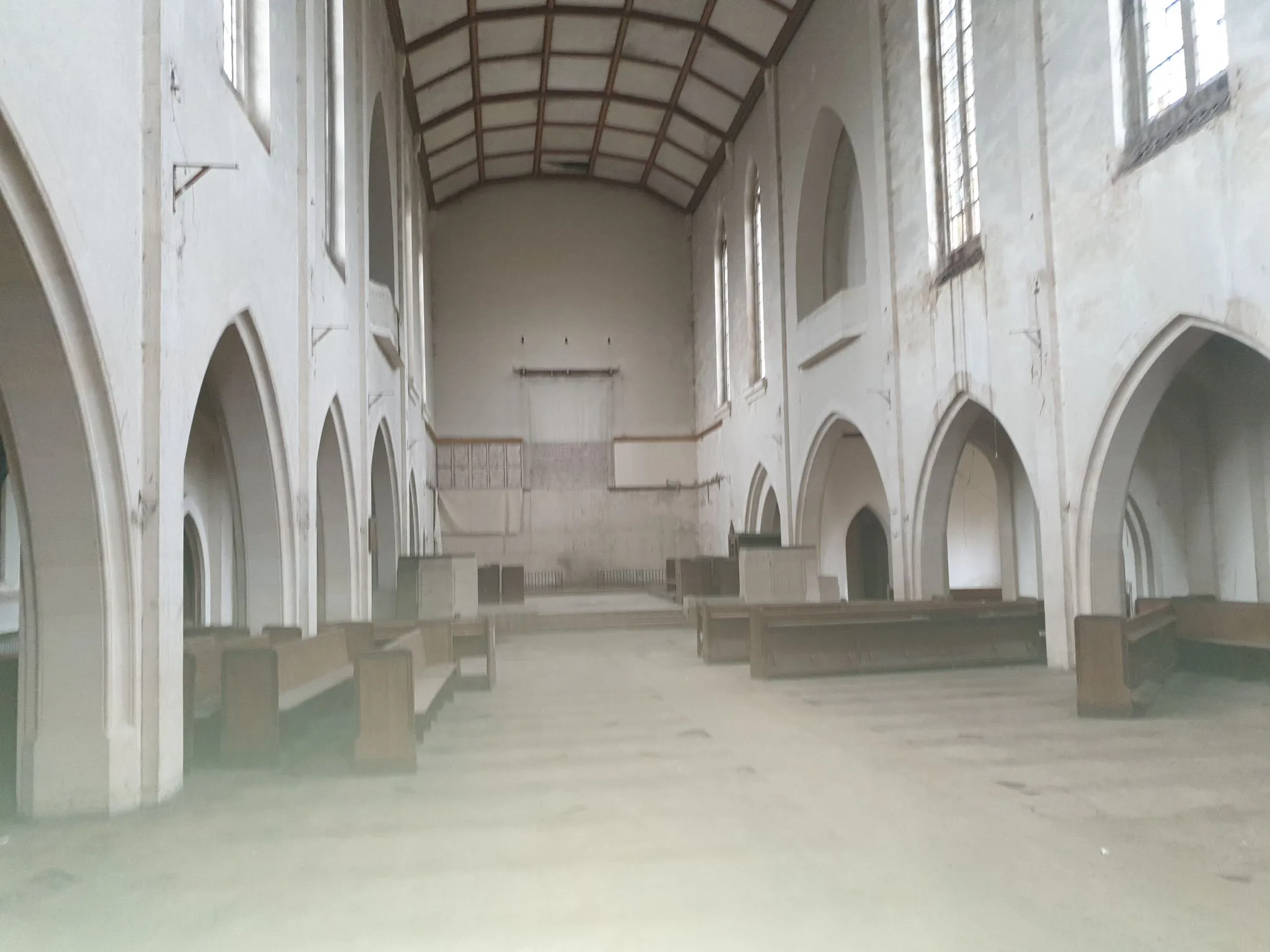 An empty church with benches in the middle.