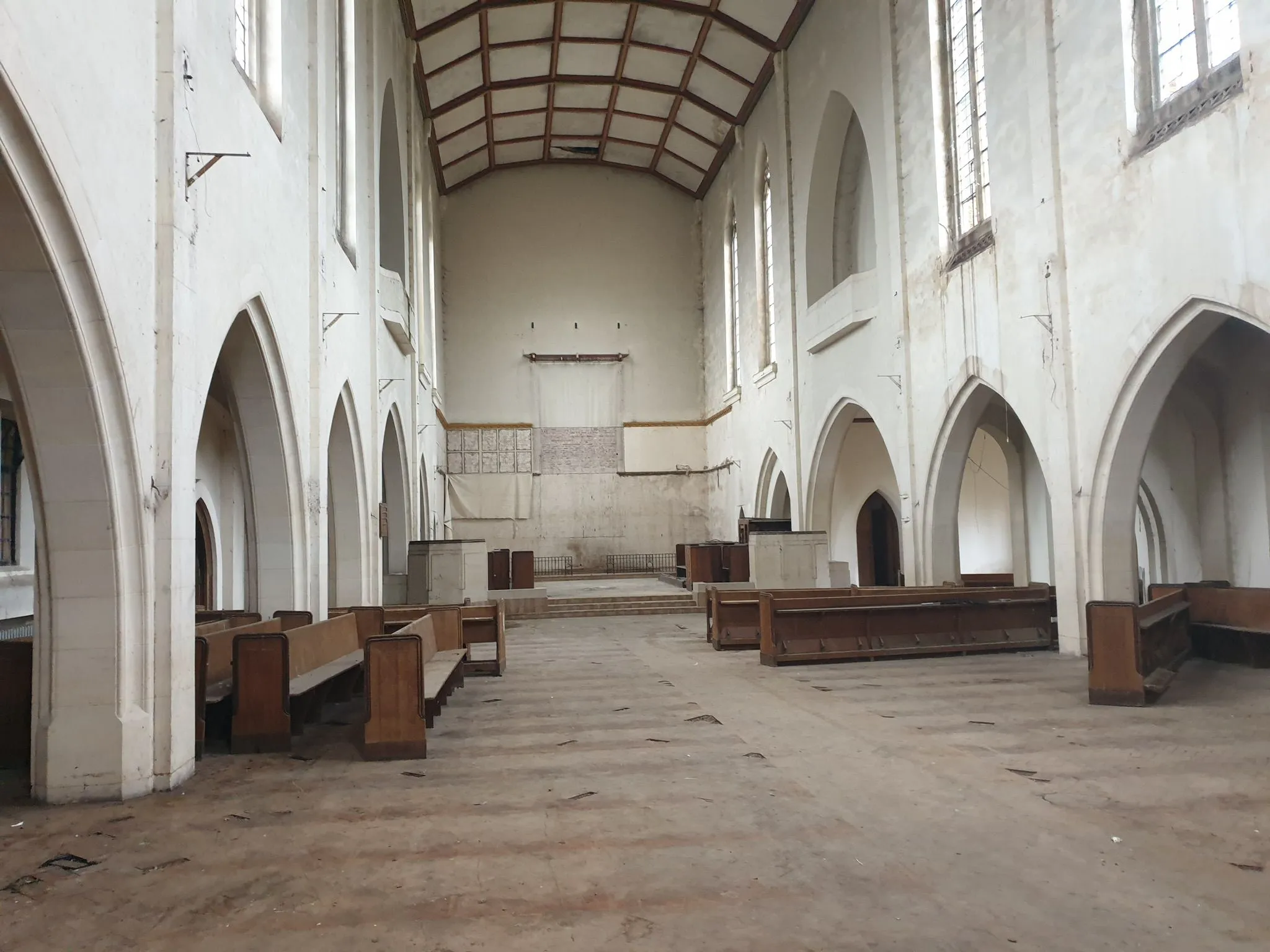 An empty church with pews in the middle of it.