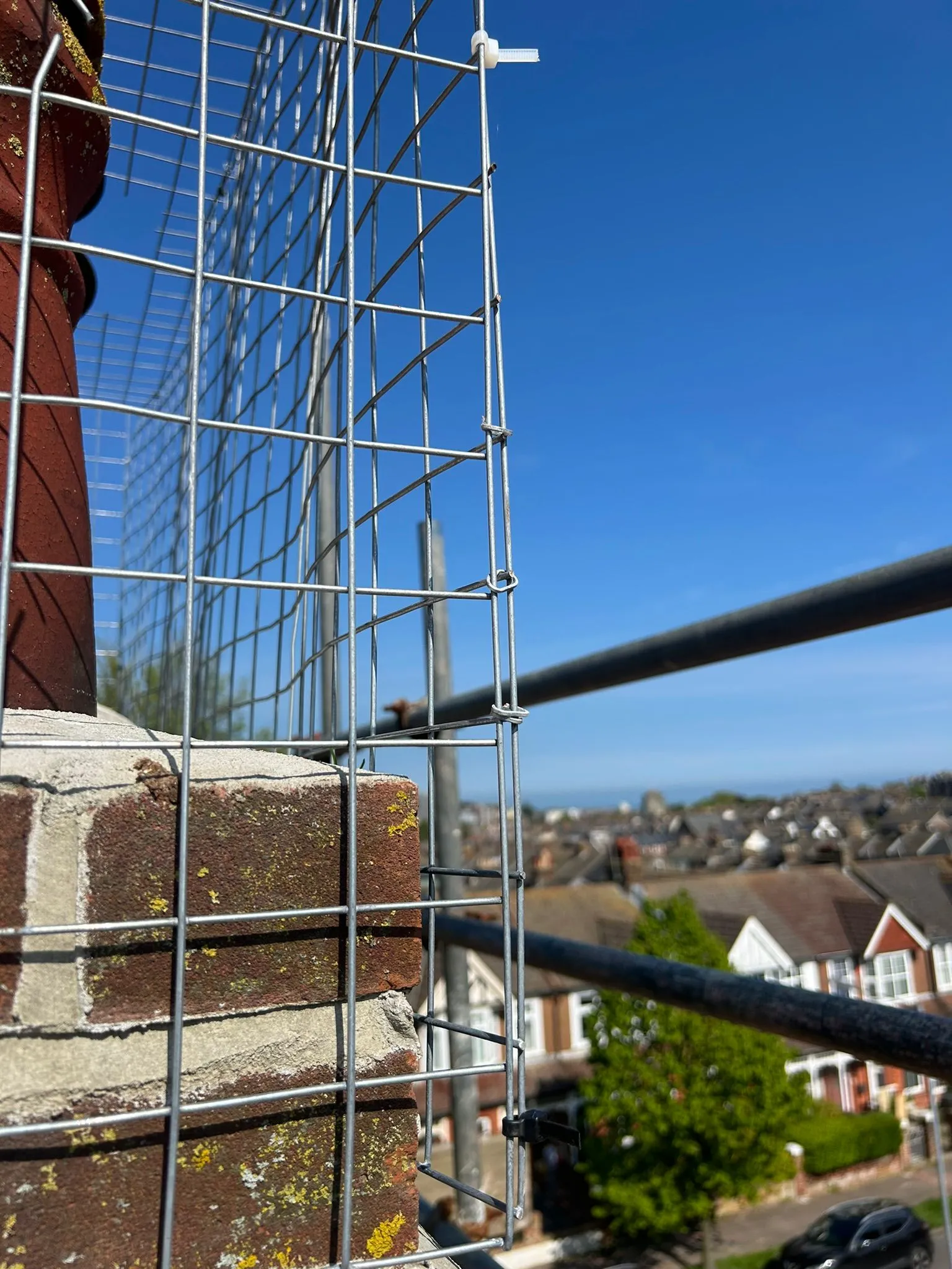 A brick wall with a wire fence surrounding it.